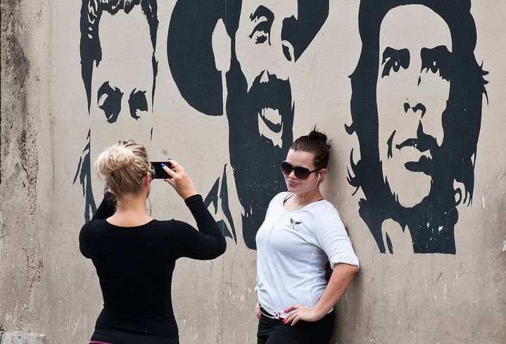 Des touristes posent devant un pochoir &agrave; l'effigie de Che Guevara, &agrave; La Havane (Cuba), le 7 janvier 2015.&nbsp; (YAMIL LAGE / AFP)