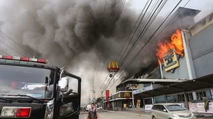 Les flammes ravagent un centre commercial de Davao (île de Mindanao, Philippines), le 23 décembre 2017. (MANMAN DEJETO / AFP)