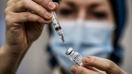 Une soignante prépare une dose de vaccin Pfizer-BioNTech contre le Covid-19, dans un centre de vaccination à Lyon, le 27 novembre 2021. (JEFF PACHOUD / AFP)