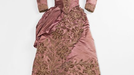 La comtesse Greffulhe s’est montrée fidèle à certains couturiers. Cette élégante robe de jour, mêlant des couleurs éteintes qu’elle affectionnait - en particulier le vieux rose - témoigne de son goût pour la maison Soinard. Cet établissement, oublié de nos jours, avait été le fournisseur principal de son trousseau dont une facture, datée de novembre 1878, est conservée dans le fonds Greffulhe aux Archives nationales.
	 
 (Julien Vidal / Galliera / Roger-Viollet)