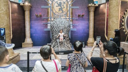 Des visiteurs devant une réplique du Trône de fer, le 9 août 2017 à Shanghai (Chine). (WANG GANG / IMAGINECHINA / AFP)