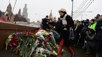 Des Moscovites d&eacute;posant, samedi 28 f&eacute;vrier, des fleurs &agrave; l'endroit o&ugrave; l'opposant Boris Nemtsov a &eacute;t&eacute; tu&eacute; la veille, &agrave; deux pas du Kremlin &agrave; Moscou (Russie). (SEFA KARACAN / ANADOLU AGENCY / AFP)