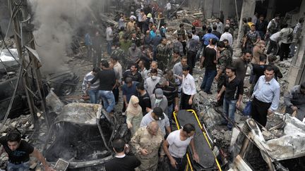 Des Syriens dans le quartier de Mazz&eacute;, &agrave; Damas (Syrie), o&ugrave; un attentat suicide a &eacute;t&eacute; perp&eacute;tr&eacute; le 5 novembre 2012. ( SANA / AFP)