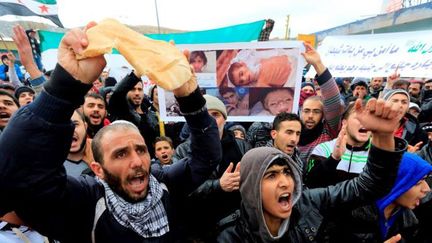 Brandissant du pain et des photos d'enfants morts de faim, des manifestants dans la plaine de la Bekaa au Liban ont dénoncé, le 8 janvier 2015, le siège de la ville de Madaya en Syrie par le régime d'Assad et ses alliés du Hezbollah. (Ratib Al Safadi / Anadolu Agency)