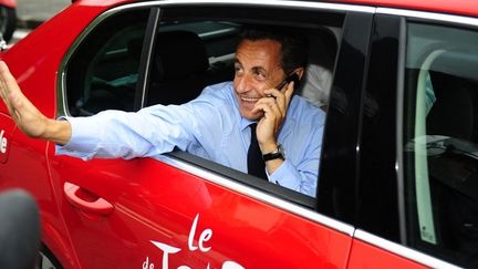 Nicolas Sarkozy sur la route du Tour de France n’arrive pas à lâcher son portable… (LIONEL BONAVENTURE / AFP)