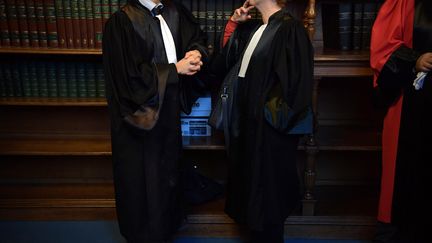 Deux avocats discutent au tribunal de grande instance de Paris, en 2017. (CHRISTOPHE ARCHAMBAULT / AFP)