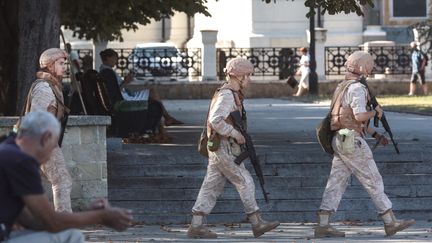 Des soldats russes patrouillent devant un quartier général de la flotte russe à Sébastopol, en Crimée, le 31 juillet 2022. (STRINGER / AFP)