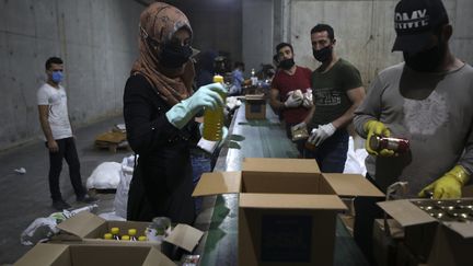 Des bénévoles libanais remplissent des cartons de nourriture pour aider les familles dans le besoin&nbsp;en pleine épidémie de coronavirus, le 29 mai 2020 à Beyrouth (photo d'illustration). (PATRICK BAZ / AFP)