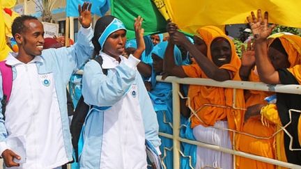 Mohammed Hassan et ZamZam Farah saluant leurs supporters lors du départ de Mogadiscio, le 17 juillet 2012. (AFP/MOHAMMED ABDIWAHAD)