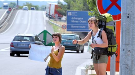 Quand arrive l'été, les pancartes des auto-stoppeurs fleurissent sur le bord des routes. (GUILLAUME BONNEFONT / MAXPPP)