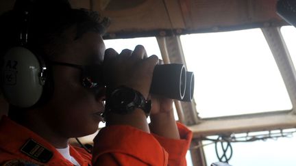 Un membre de l'arm&eacute;e de l'air indon&eacute;sienne participant aux recherches de l'avion d'AirAsia disparu depuis dimanche 28 d&eacute;cembre au dessus de la mer de Java. (AGUNG KUNCAHYA B. / XINHUA / SIPA)