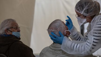 Une membre du personnel médical effectue un test Covid-19 le 13 janvier 2021 à Saint-Etienne (Rhônes-Alpes). (JEAN-PHILIPPE KSIAZEK / AFP)