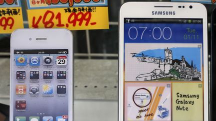 Dans une boutique de Tokyo (Japon), le 31 ao&ucirc;t 2012, deux t&eacute;l&eacute;phones portables Apple et Samsung. (KIM KYUNG HOON / REUTERS)