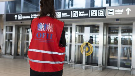 Une bénévole de l'Office francais de l'Immigration et de l'Integration (OFII) attend l'arrivée de migrants à l'aéroport Lyon-Saint-Exupéry en 2017. (ROMAIN LAFABREGUE / AFP)