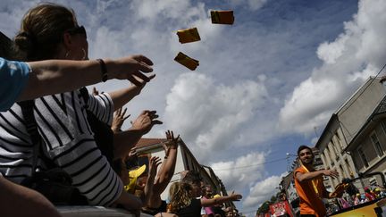 Les spectateurs du Tour de France reçoivent des goodies offerts lors du passage de la caravane, à Longwy (Meurthe-et-Moselle). (JEFF PACHOUD / AFP)