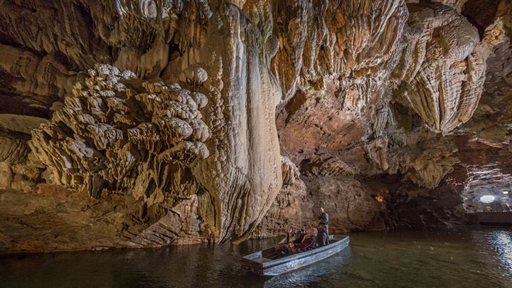 En période estivale, une vingtaine de barques permettent aux visiteurs de naviguer sur la rivière qui coule à l'intérieur du Gouffre de Padirac. C'est un guide qui les conduit. (GOUFFRE DE PADIRAC)