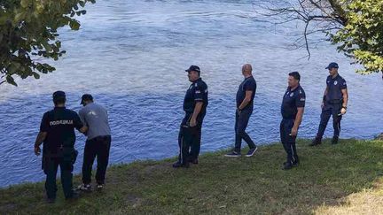 Des officiers de la police serbe fouillent les bords de la Drina près de la ville de Ljubovija, en Serbie, le jeudi 22 août 2024. (AP / SIPA)