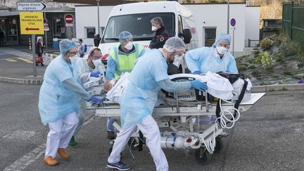 Des soignants s'affairent pour évacuer un patient de l'hôpital Emile Muller de Mulhouse, pour le transférer vers un autre établissement. (SEBASTIEN BOZON / AFP)