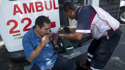 Un membre de la Croix-Rouge mexicaine s'occupe d'un homme, apr&egrave;s le puissant s&eacute;isme qui a secou&eacute; le Mexique, le 20 mars 2012.&nbsp; (YURI CORTEZ / AFP)