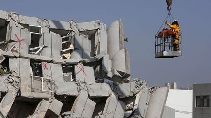 Des secouristes extraient un corps du bâtiment de 17 étages qui s'est effondré, à Tainan, après le séisme du 6 février 2016. (TYRONE SIU / REUTERS)