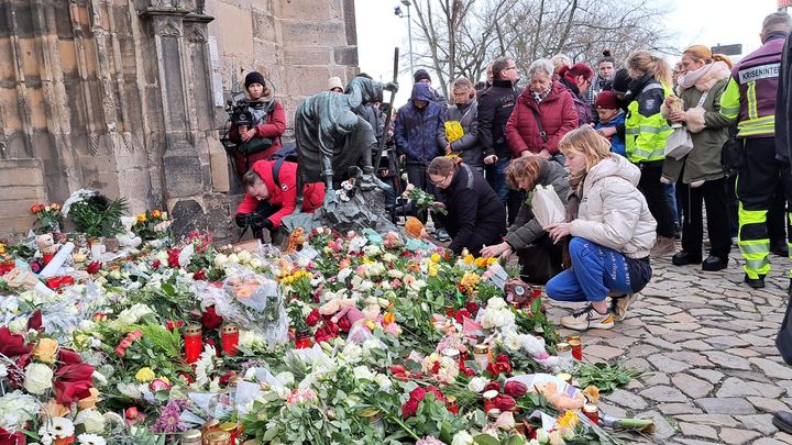 Des personnes déposent des fleurs et des bougies près du site de l'attaque à la voiture-bélier sur un marché de Noël à Magdebourg en Allemagne, le 21 décembre 2024. (BENJAMIN ILLY / RADIO FRANCE)