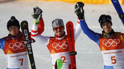 Les skieurs français Alexis Pinturault Victor Muffat-Jeandet autour de l'Autrichien Marcel Hirscher sur le podium du combiné, aux Jeux olympiques de Pyeongchang (Corée du Sud), le 13 février 2018.&nbsp;&nbsp; (LEONHARD FOEGER / REUTERS)