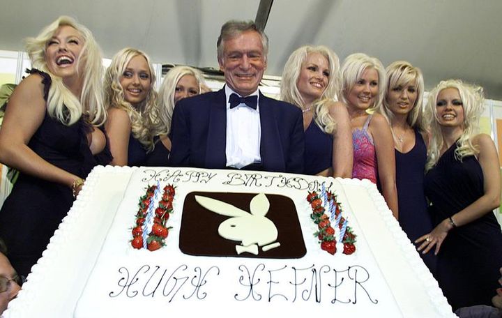 Hugh Hefner (G) avec son gâteau d'anniversaire lors de ses 75 ans fêtés à Cannes (Alpes-Maritimes), le 12 mai 2001. (JEAN-PAUL PELISSIER / SIPA)