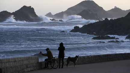 Des habitants contemplent la mer agitée lors d'une tempête, le 21 février 2022 à Ajaccio (Corse-du-Sud). (PASCAL POCHARD-CASABIANCA / AFP)