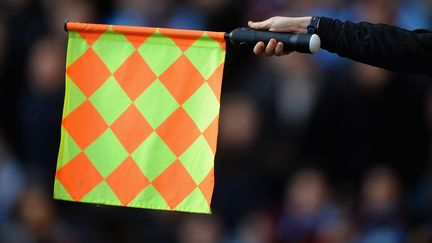 Un arbitre assistant brandit un drapeau de hors-jeu le 26 f&eacute;vrier 2011 &agrave; Birmingham (Royaume-Uni). (LAURENCE GRIFFITHS / GETTY IMAGES)