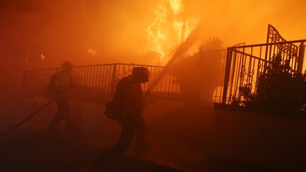 Des pompiers combattent le feu&nbsp;Saddleridge à Porter Ranch en Californie, le 11 octobre 2019. (MARIO TAMA / GETTY IMAGES NORTH AMERICA)