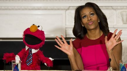 Michelle Obama donne une conf&eacute;rence de presse &agrave; la Maison blanche, &agrave; Washington (Etats-Unis), en compagnie d'Elmo, personnage de l'&eacute;mission "Rue S&eacute;same", le 30 octobre 2013. (SAUL LOEB / AFP)