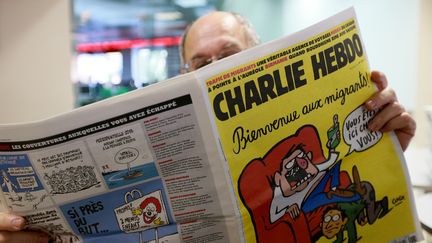 Un homme lit le numéro de "Charlie Hebdo" paru le 18 septembre 2015. (ANTON DENISOV / RIA NOVOSTI / AFP)