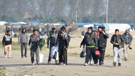 Des migrants quittent "la jungle" de Calais pendant l'évacuation du camps, le 25 octobre 2016. (DENIS CHARLET / AFP)