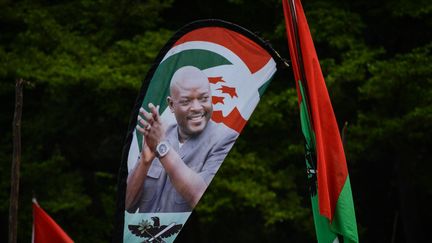 Un portrait du président burundais Pierre Nkurunziza, décédé le 8 juin 2020,&nbsp;imprimé&nbsp;sur un drapeau lors d'un meeting du parti au pouvoir, organisé le 14 mai 2018 dans le cadre du référendum constitutionnel controversé prévu trois jours plus tard.&nbsp; (STRINGER / AFP)