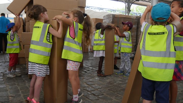 Des enfants aident à assembler les cartons, mercredi 19 juillet
 (Elise Koutnouyan / Culturebox)