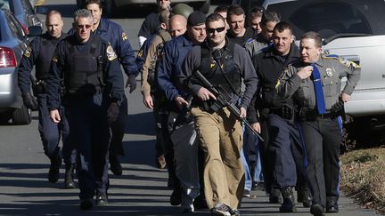 Des policiers patrouillent dans les rues aux abords de l'&eacute;cole &eacute;l&eacute;mentaire Sandy Hook, th&eacute;&acirc;tre de la fusillade la plus meurtri&egrave;re &nbsp;survenue dans une &eacute;cole am&eacute;ricaine.&nbsp; (ADREES LATIF / REUTERS)