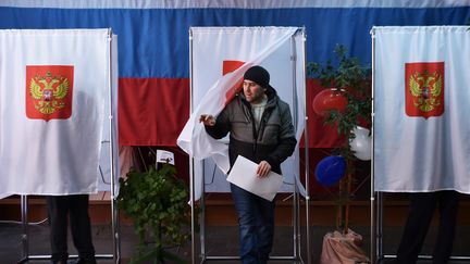 Un homme sort d'un isoloir, le 18 mars 2018, à Novye Bateki (Russie). (SERGEI GAPON / AFP)