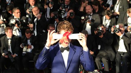 Le r&eacute;alisateur canadien Xavier Dolan pose avec son Prix du jury obtenu pour "Mommy" au festival de Cannes, le 24 mai 2014. (LOIC VENANCE / AFP)