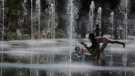 Des enfants se rafraîchissent dans une fontaine à Nice (Alpes-Maritimes), le 27 juin 2019.&nbsp; (ERIC GAILLARD / REUTERS)