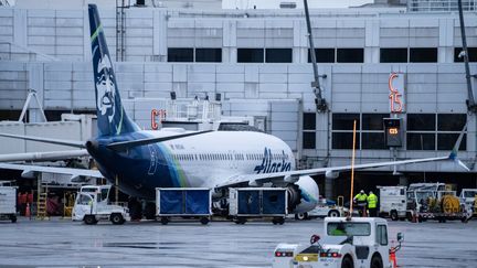 Un Boeing 737 MAX 9 de la compagnie Alaska Airlines est bloqué à une porte d'embarquement de l'aéroport international de Seattle-Tacoma, à Washington (Etats-Unis), le 6 janvier 2024. (STEPHEN BRASHEAR / GETTY IMAGES / AFP)