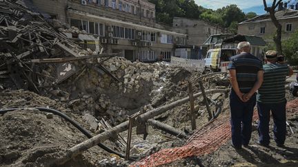 Des hommes sur les lieux d'une attaque russe sur un bâtiment d'Odessa, dans le sud de l'Ukraine, le 25 juillet 2023. (ERCIN ERTURK / ANADOLU AGENCY / AFP)