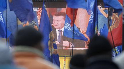 Des soutiens de Viktor&nbsp;Ianoukovitch regardent sur grand &eacute;cran une intervention du pr&eacute;sident ukrainien, le 19 d&eacute;cembre 2013, &agrave; Kiev (Ukraine). (GLEB GARANICH / REUTERS)