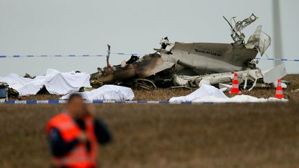 Les corps des victimes du crash d'un avion &agrave; Fernelmont (Belgique) sont align&eacute;s devant la carcasse de l'appareil, le 19 octobre 2013. (MAXPPP)