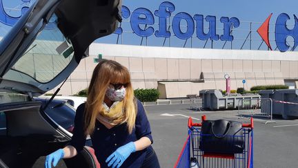 Une cliente d'un magasin de grande distribution Carrefour charge sa voiture de victuailles à Caen (Calvados). (OLIVIER DUC / FRANCE-BLEU BASSE-NORMANDIE)