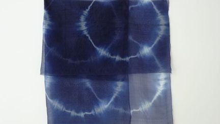 Le bleu n’est pas une surface, son regard s’enfuit dans le bleu. Comment rendre cette énergie, comment faire glisser la couleur. Voiles, sculptures, parures textiles, teints à la main par des techniques personnelles de shibori (teintures par réserves). Plier, rouler, ligaturer des matières pour devenir volumes protégeant leurs secrets. Lier un tissu est comme resserrer un instant, retenir une mémoire. Suggérer la lumière, celle qui flotte même quand on ne la voit presque plus, ces moments éphémères comme des passages d’un instant à l’autre. Envelopper le corps et son espace, habiter les vides et les pleins. 
