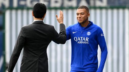 Kylian Mbappé et Nasser Al-Khelaïfi se saluent à l'entraînement du PSG le 5 septembre 2022. (FRANCK FIFE / AFP)