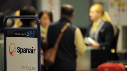 Des passagers au comptoir d'enregistrement de la compagnie Spanair &agrave; l'a&eacute;roport de Barcelone (Espagne), le 27 janvier 2012. (LLUIS GENE / AFP)