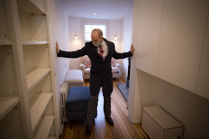 David Myers, sales manager at the agency that manages the property, shows the width of the house on 5 February 2021 in London.  (TOLGA AKMEN / AFP)