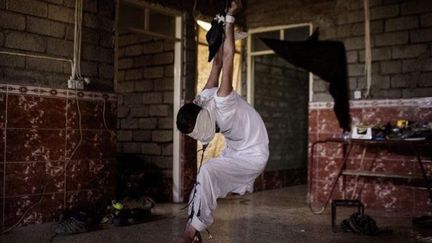 Un jeune homme suspendu au plafond et roué de coups par des soldats irakiens à Mossoul. Une des photos du reporter, Ali Arkady, publiées par l'hebdomadaire allemand Der Spiegel, sur les pratiques de la torture à l'encontre de civils accusés de sympathie pour Daech. (Ali Arkady pour Der Spiegel)