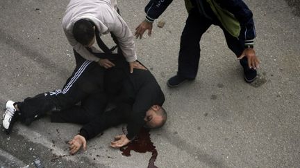 Un homme gri&egrave;vement bless&eacute; apr&egrave;s un tir d'obus &agrave; Homs (Syrie), le 11 janvier 2012. (JOSEPH EID / REUTERS)